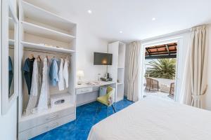 a bedroom with a bed and a desk and a window at Giardino Eden Resort in Ischia Town +40 photos