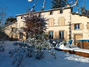a house with a snow covered yard in front of a building at le Logis d'Argenson in Beaulieu-sous-Parthenay