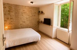 a bedroom with a white bed and a window at le Logis d'Argenson in Beaulieu-sous-Parthenay