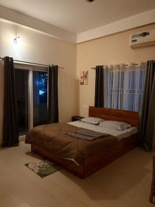 a bedroom with a bed and a large window at Mong Mao Manor in Guwahati