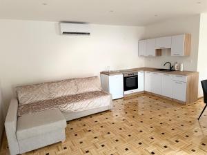 a living room with a bed and a kitchen at Apartma Viković II in Njiverce