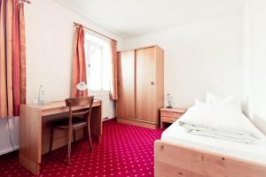 a bedroom with a desk and a bed and a desk and a chair at Schweiger's Landgasthof in Wartenberg +10 photos