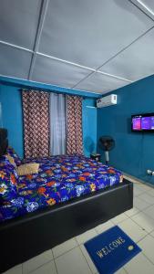 a bed in a room with a blue wall at King Appartement in Lomé