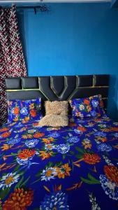 a bed with a colorful bedspread with flowers on it at King Appartement in Lomé