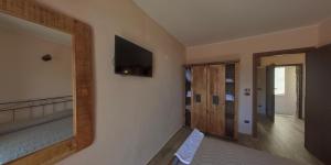 a bedroom with a bed and a television on a wall at Borgo Tibetano in Castelsaraceno