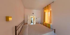 a bedroom with a bed and a window at Borgo Tibetano in Castelsaraceno