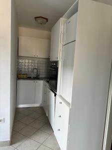 a kitchen with white cabinets and a refrigerator at Apartmani Nadalina in Veli Lošinj +94 photos