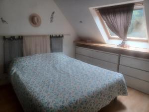 a bedroom with a bed and a window at les Arômes in Locronan