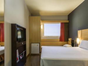 a bedroom with a large bed and a window at ibis Barretos in Barretos