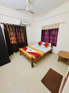 a bedroom with a bed and a window with curtains at Hotel SAI GRAND in Mangalore