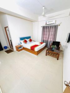 a hotel room with a bed and a chair at Hotel SAI GRAND in Mangalore
