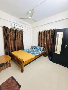 a small bedroom with a bed and a table at Hotel SAI GRAND in Mangalore +3 photos