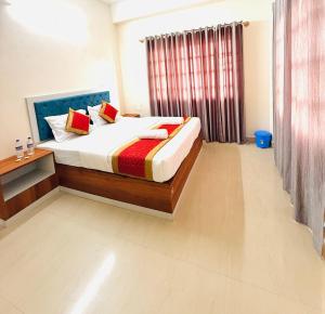 a bedroom with a bed and a table and a window at Hotel SAI GRAND in Mangalore