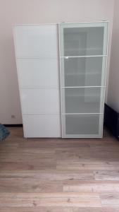 a closet with a glass door and a wooden floor at appartement de 45 m sur cour centre ville de morez in Morez
