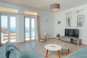 a living room with a couch and a tv at Sea and Sun l in Mylopotas