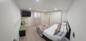a hotel room with a bed and a television at Casa Sobreira de Mondim in Mondim de Basto