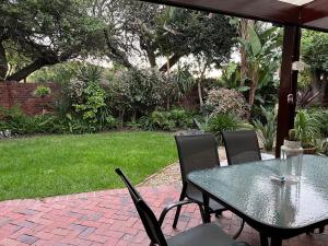 a table and chairs sitting on a brick patio at Indigo Nest in Edgemead