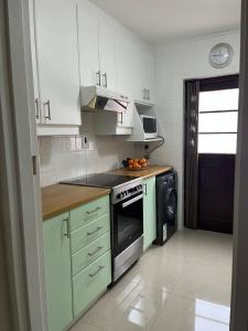 a kitchen with white cabinets and a stove top oven at Indigo Nest in Edgemead
