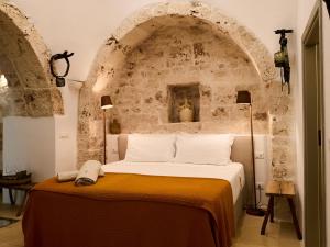 a bedroom with a bed in a stone wall at Dimora Dei Semplici in Ostuni +159 photos