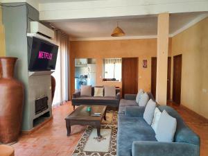 a living room with a couch and a tv at Darna in Marrakesh