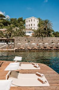 a group of chairs and umbrellas on a dock at Giardino Eden Resort in Ischia Town