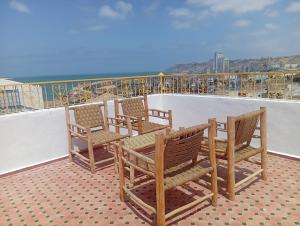 a group of chairs sitting on top of a balcony at Dar Salam Asfi - Maison d'hôtes, terrasse vue Medina et océan in Safi