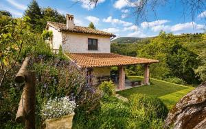 a small house in a garden with flowers at VILLA NOCRI - Villa Privata con Piscina & Sauna in Montefranco