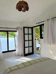 a bedroom with a bed and large windows at La Calita de Teques in Tequesquitengo +70 photos