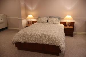 a bedroom with a large bed and two lamps at Cozy Family Suite, entire place with two beds, pravite washroom and kitchen in Markham