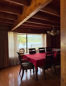 a dining room with a red table and chairs at Casa Costanera in Panguipulli
