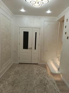 a bathroom with a white door and a tub at Sherine house in Tamga +3 photos