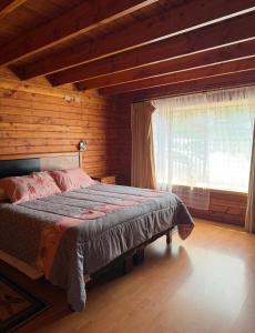 a bedroom with a bed in a wooden room at Casa Costanera in Panguipulli