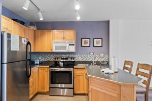 a kitchen with wooden cabinets and a stainless steel refrigerator at Buffalo Lodge #8392 in Keystone