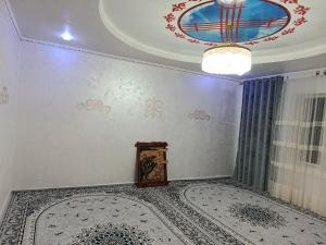 a room with a ceiling with a chandelier and a rug at Sherine house in Tamga