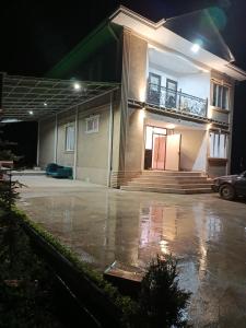 a house in a parking lot at night at Sherine house in Tamga