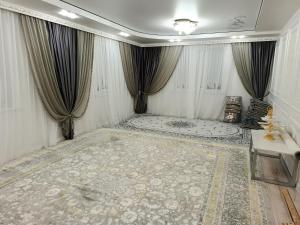 a room with curtains and a large rug at Sherine house in Tamga