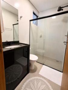 ein Badezimmer mit Dusche, Waschbecken und Toilette in der Unterkunft Flat AR Moderno com Ar Condicionado e Estacionamento in Rio Claro