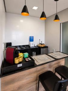 eine Küche mit einer Theke und einem Tisch mit Gepäck in der Unterkunft Flat AR Moderno com Ar Condicionado e Estacionamento in Rio Claro + 6 Fotos