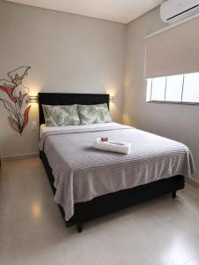 ein Schlafzimmer mit einem Bett, auf dem ein Handtuch liegt in der Unterkunft Flat AR Moderno com Ar Condicionado e Estacionamento in Rio Claro