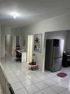 a living room with a refrigerator and a table at Quarto individual Quarto 2 in Montes Claros