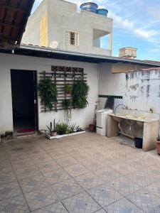 a building with a patio with a sink and plants at Quarto individual Quarto 2 in Montes Claros