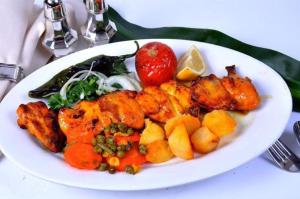 a plate of food with chicken and vegetables on a table at DREAM Flat in PARIS in Levallois-Perret