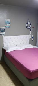 a bed in a room with a pink and purple mattress at Verde Mar Abricó 4 in Rio das Ostras
