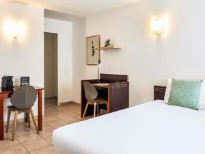 a hotel room with a bed and a desk at Aparthotel Adagio Access Nice Garibaldi in Nice