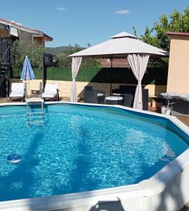 a swimming pool with an umbrella and a table and chairs at Casa Carla in Sotoserrano