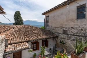 a house with a tile roof with mountains in the background at Kitarat Berat Castle in Berat