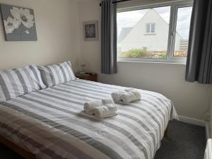 a bedroom with two towels on a bed with a window at Copthorne - Tintagel in Tintagel