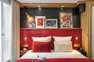 a bedroom with a bed, a dresser, and a lamp at Hotel Ducs de Bourgogne in Paris