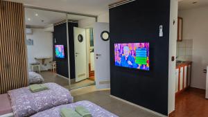 a room with two beds and a tv on a wall at Apartman i Studio apartman Majoli in Kukuljanovo