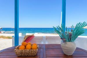 a table with two baskets of oranges on the beach at Esperanza Home Mandrakia in Mandrakia +37 photos